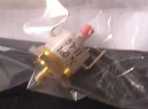 Sicherheits-Thermostat von Remeha, in transparentem Verpackungsmaterial, mit einer roten Kappe und mehreren Anschlüssen auf einem dunklen Untergrund.